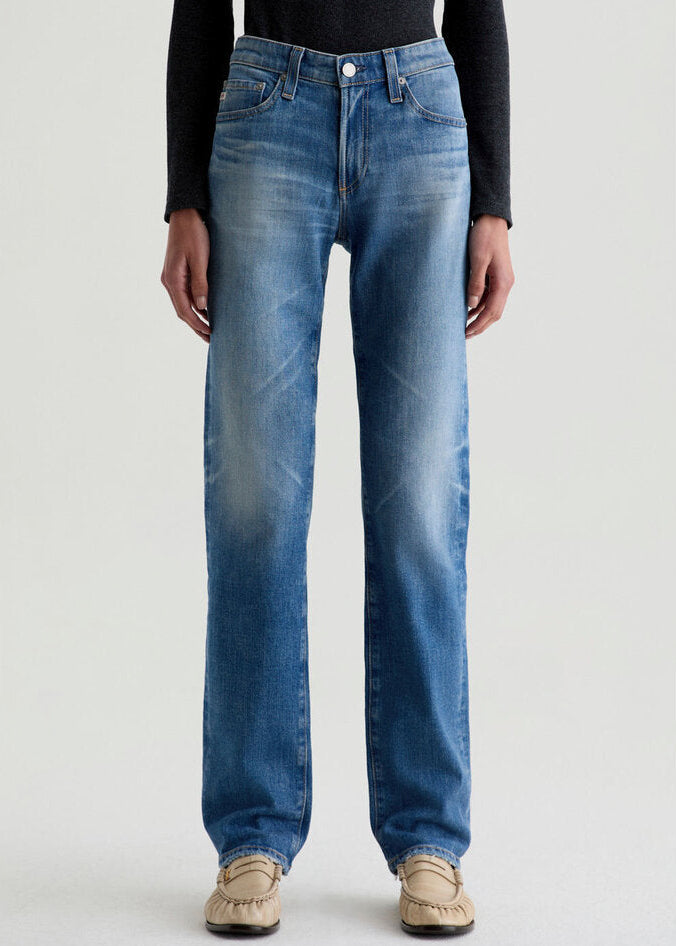 Person wearing blue jeans on a plain background